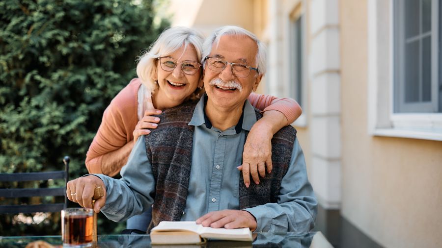 Happy senior couple at independent living community looking at camera.